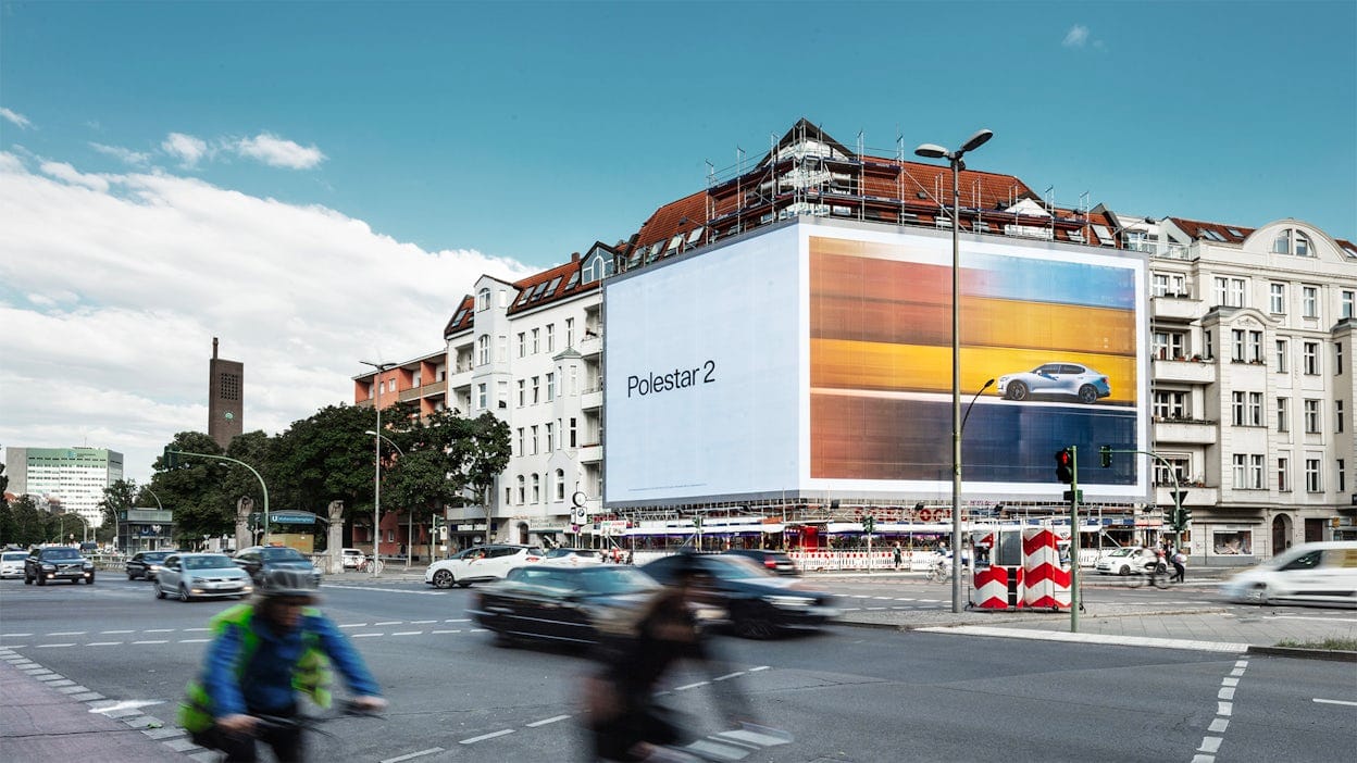 Large billboard of Polestar 2 displayed on city buildings.