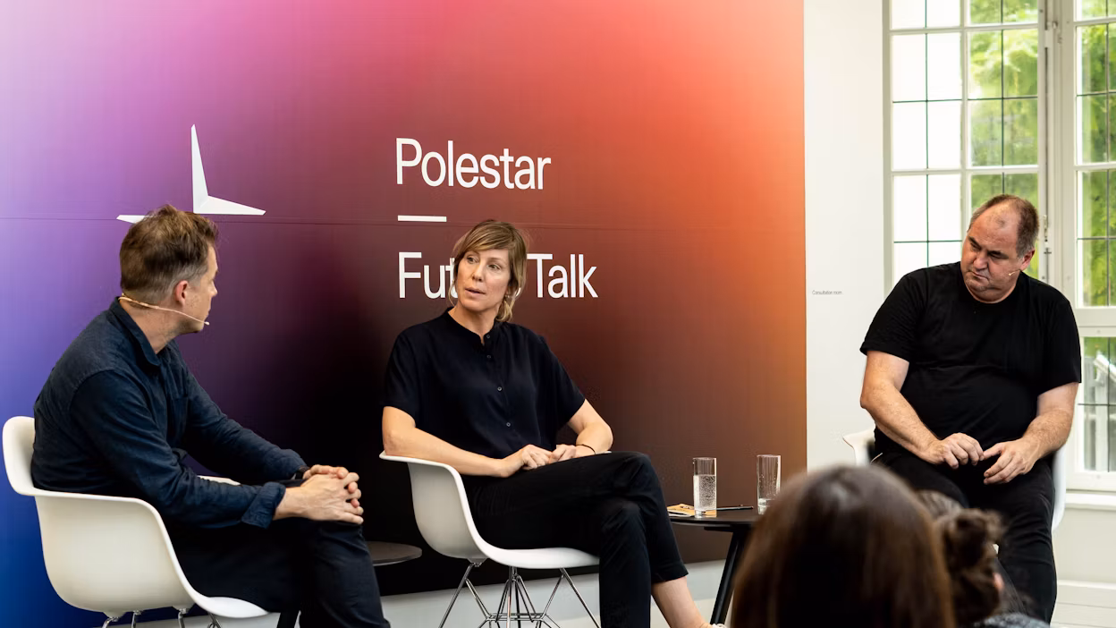 Three people seated on chairs in front of a Polestar Future Talk backdrop, with glasses of water on a table nearby.