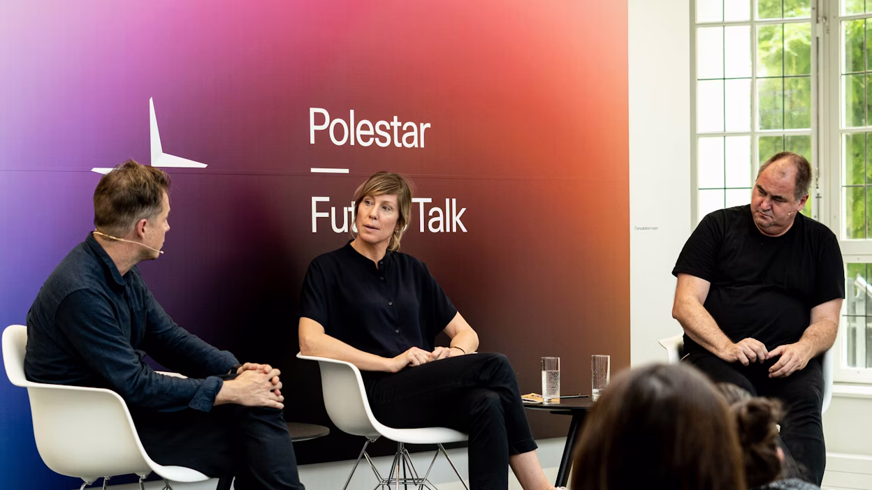 Three people seated on chairs in front of a Polestar Future Talk backdrop, with glasses of water on a table nearby.