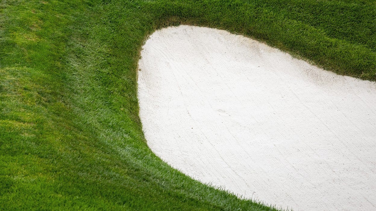 Close up of green grass and a sand bunker.