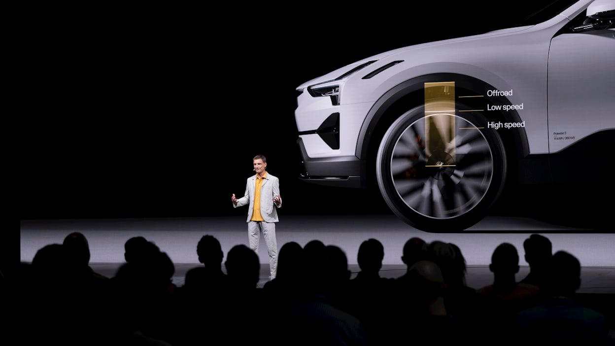A man standing on stage in front of a screen showing an infographic outlining the air suspension of Polestar 3.