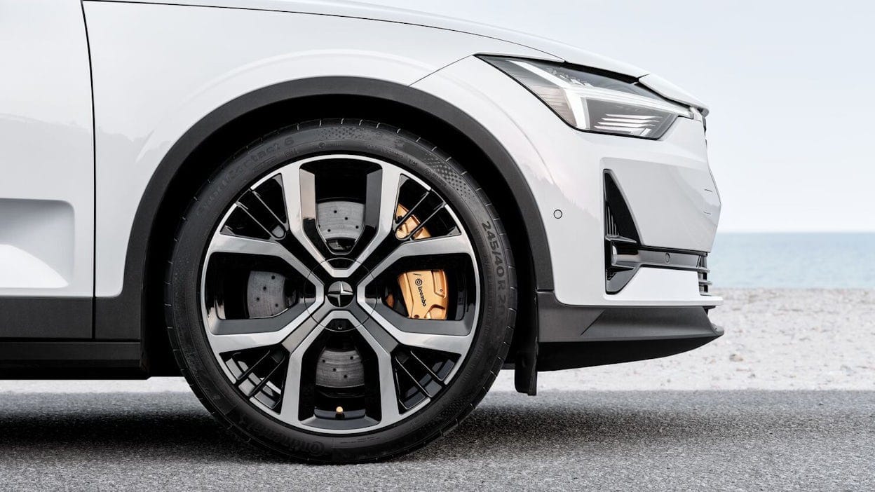 Side view of Polestar 2 hood and front wheel with golden breaks.