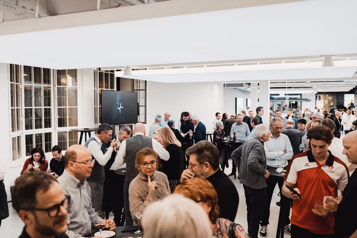 Crowd gathered in a modern indoor space with a screen displaying the Polestar logo.