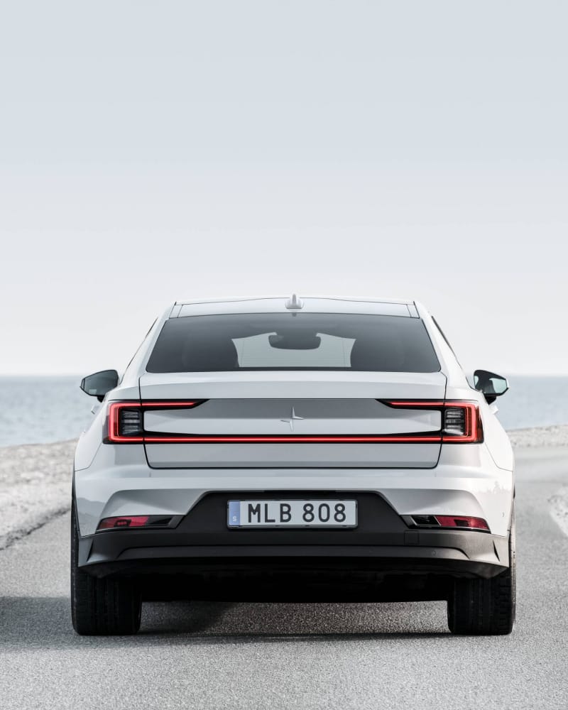 Showing the back of the Polestar 2 on a road.