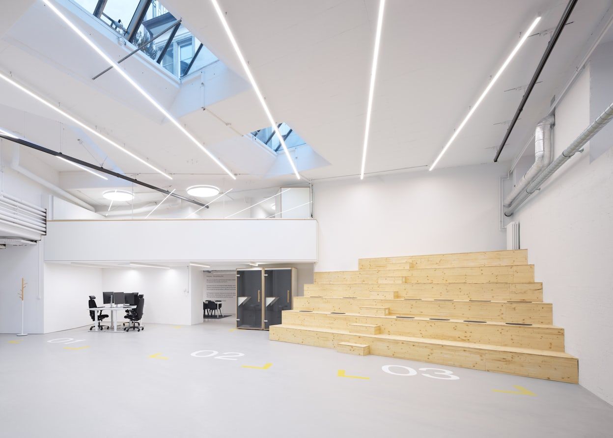 Open office space with wooden bleachers and parking spaces on the floor
