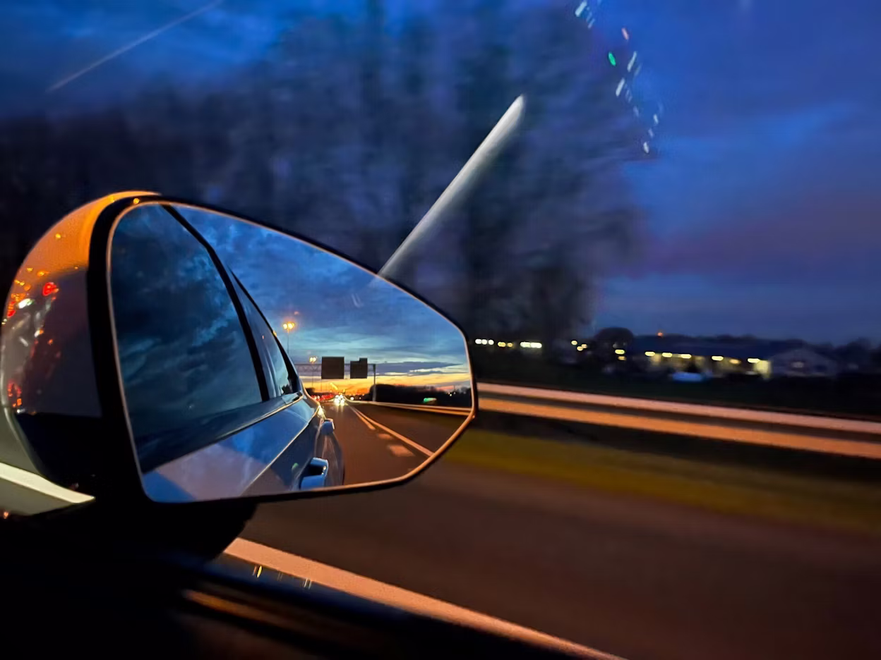 rearview mirror of a car driving in the dark