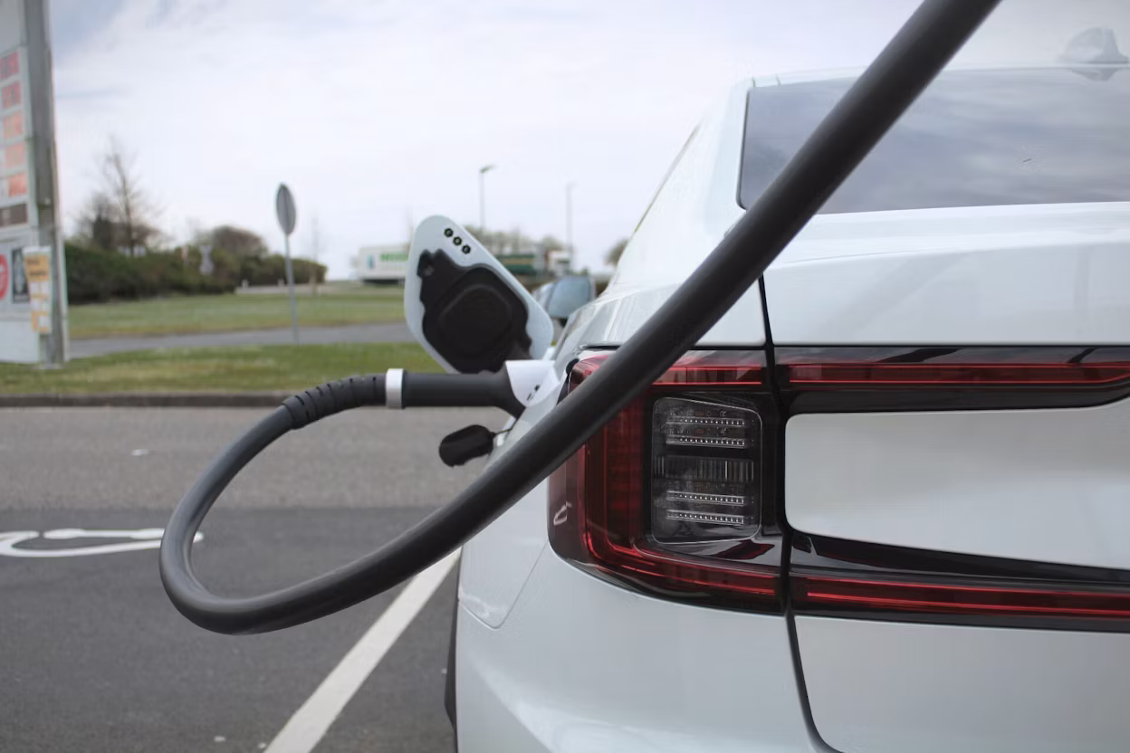 Polestar car charging at a station with cable connected to rear port.