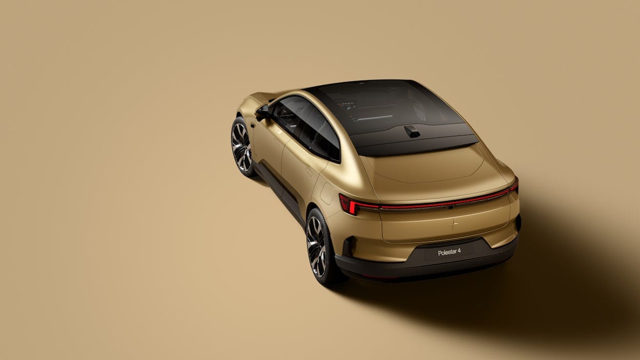 Golden Polestar 4 seen  obliquely from behind. Golden background