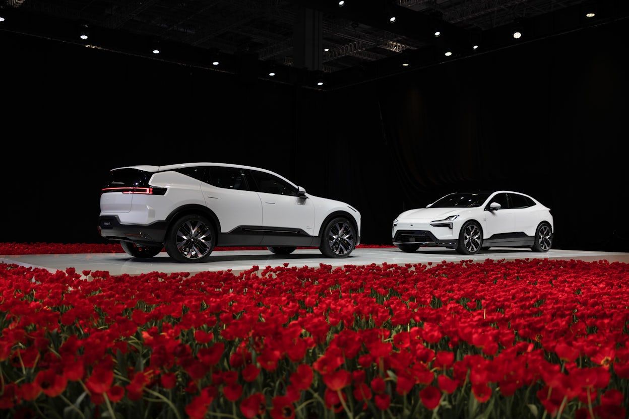 White Polestar 3 and 4 on stage facing each other among red tulips