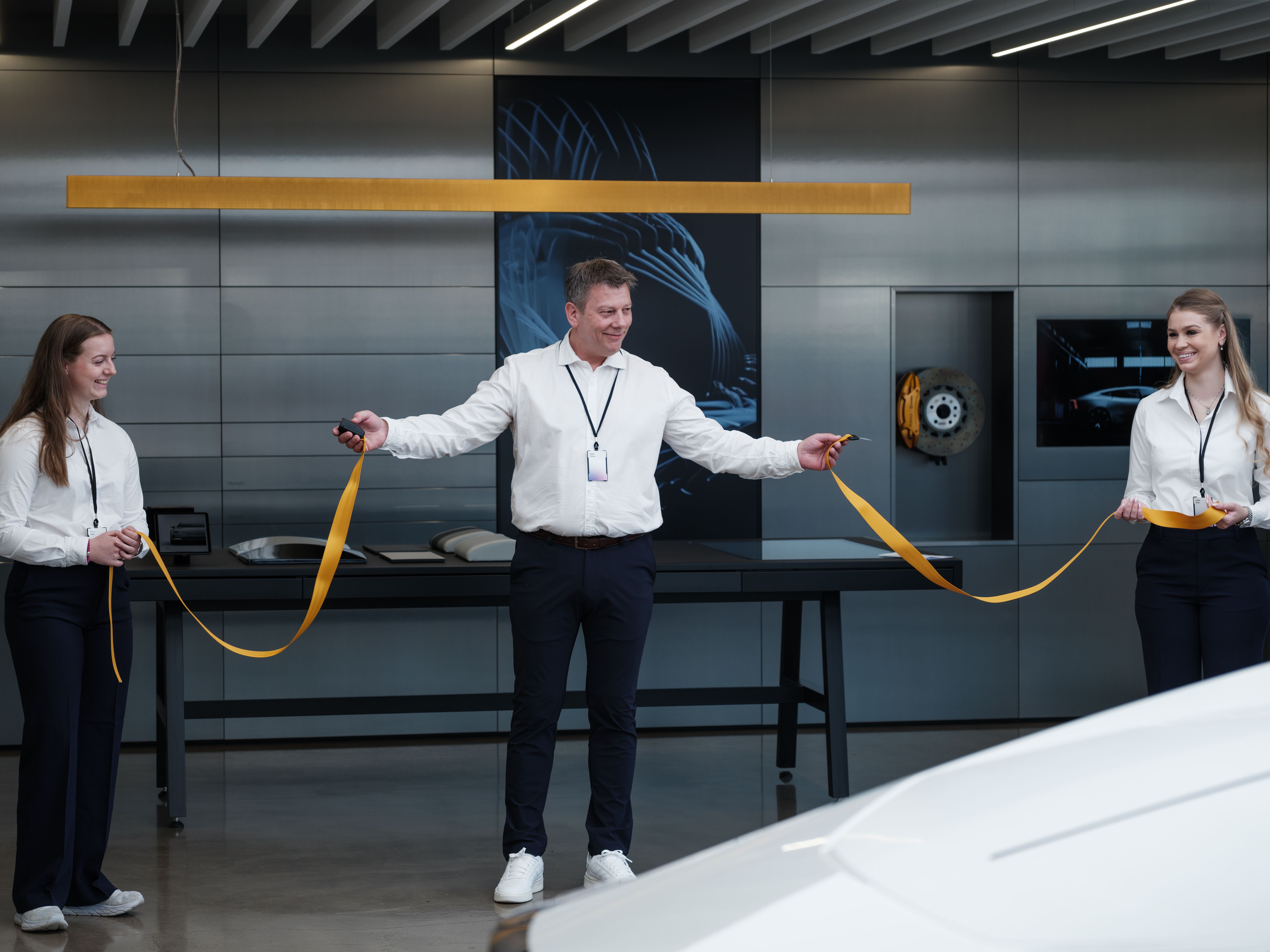 Three people cut a ribbon in connection with an inauguration of a new Polestar space