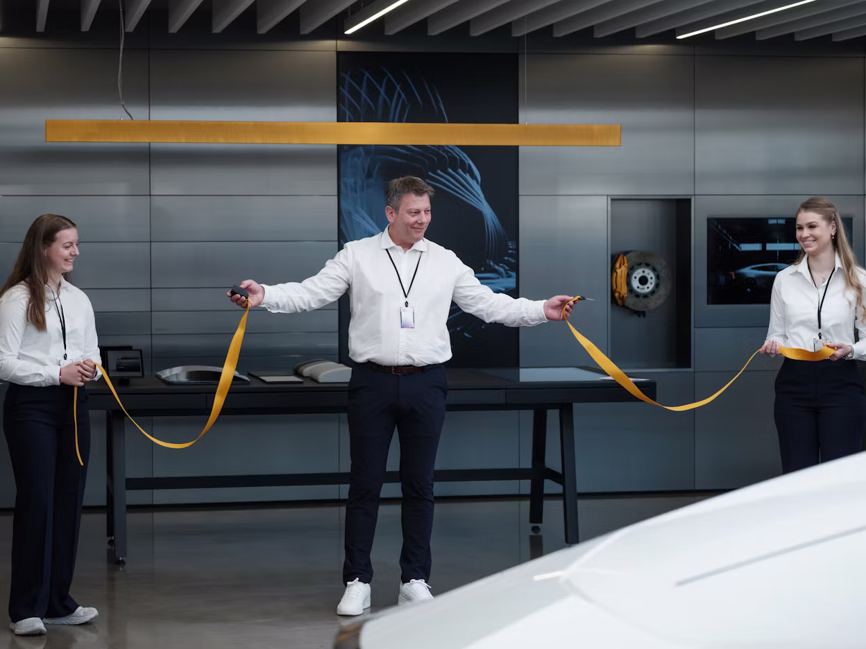 Three people cut a ribbon in connection with an inauguration of a new Polestar space