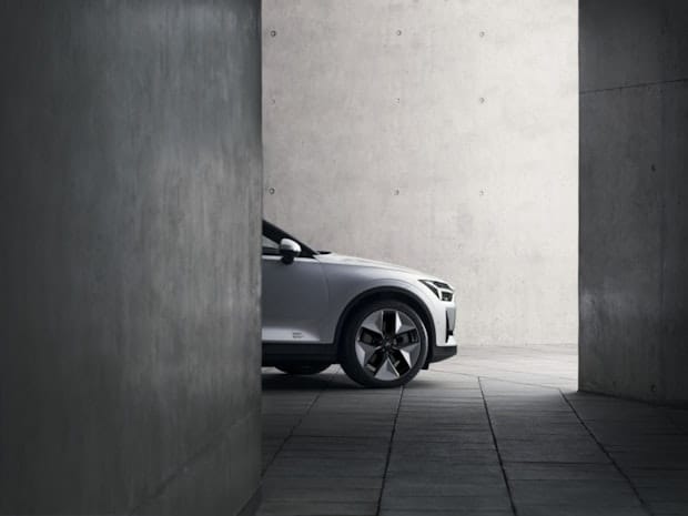The front of Polestar 2 is shownd behind a concrete wall