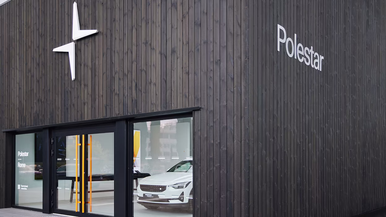 The outside of a Polestar space, dark wooden walls and white Polestar logo