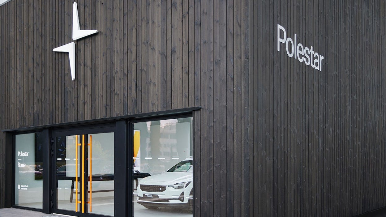 The outside of a Polestar space, dark wooden walls and white Polestar logo