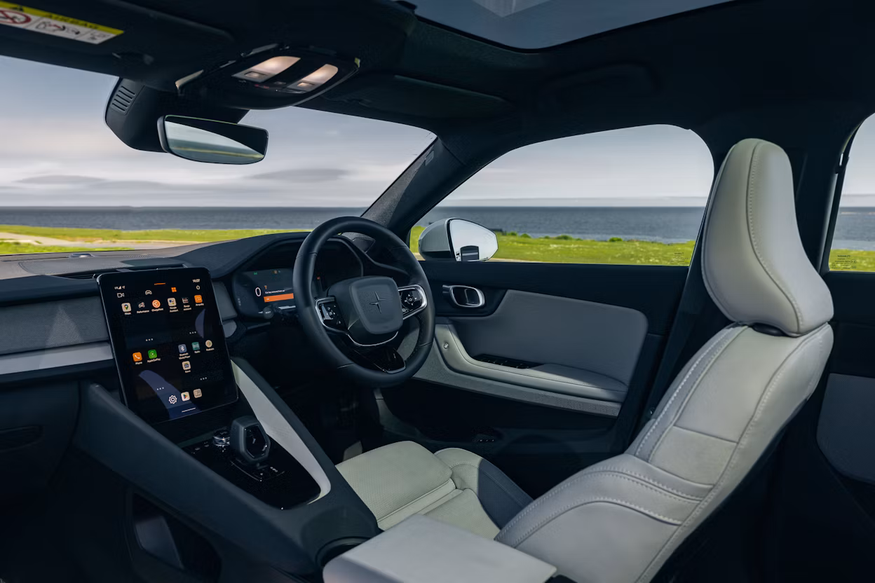 A view of a picturesque, sea-side landscape from the interior of a Polestar 2.