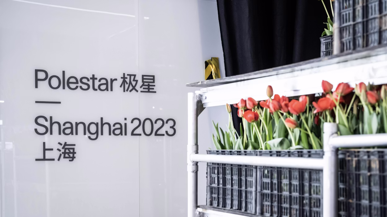 Text reads Polestar Shanghai 2023 next to crates of red tulips on a metal rack.