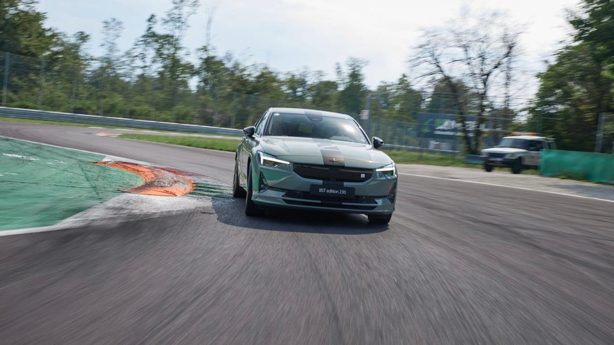 Front view of a green Polestar 2 on the race track.