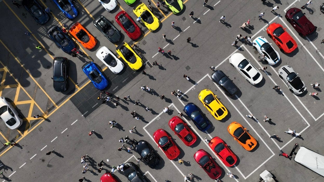 Bird's-eye view of the parking lot at Monza showing colourful cars and people.