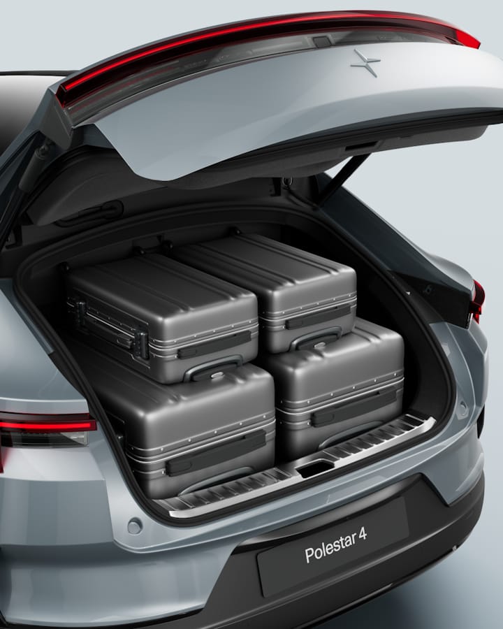 The rear luggage compartment with four grey suitcases.