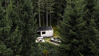 House and car in the middle of a forest