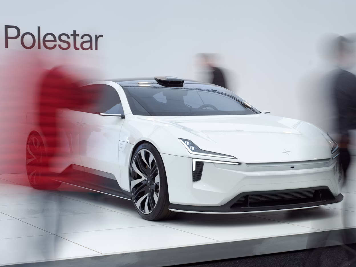 Polestar car displayed on a platform with blurred people walking around.