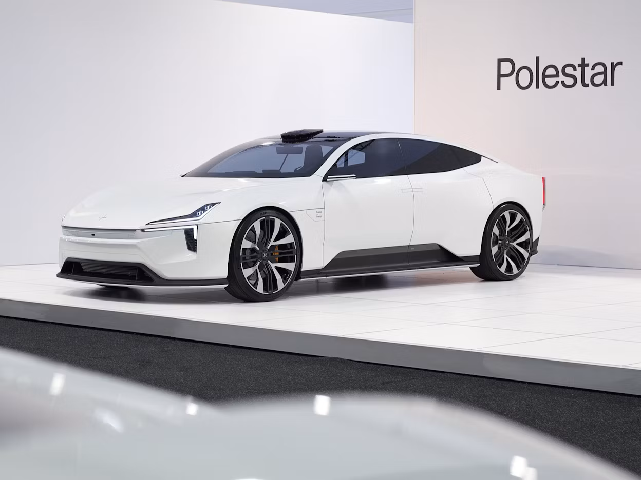 Polestar car displayed on a white platform with Polestar branding on the wall in the background.