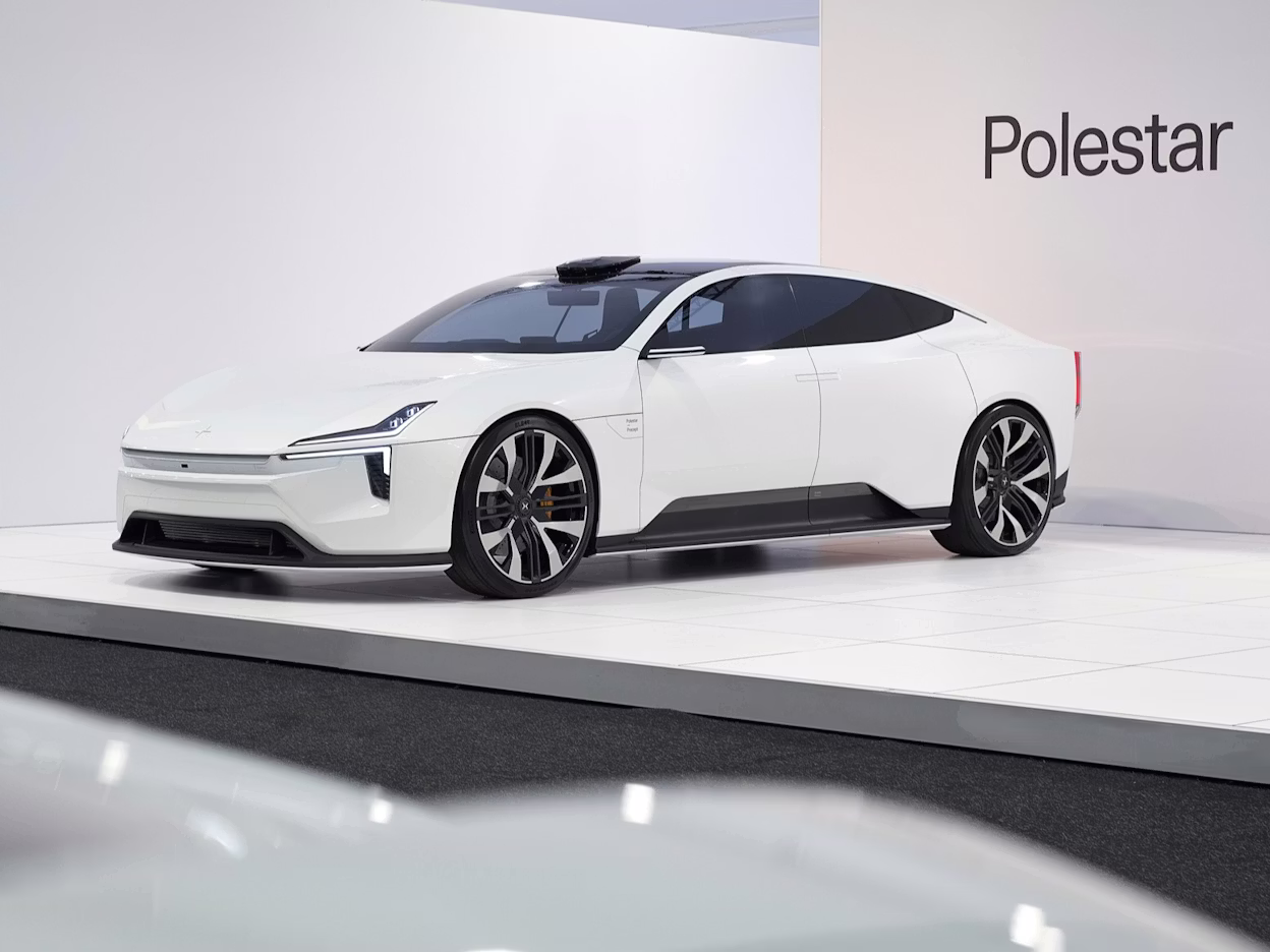 Polestar car displayed on a white platform with Polestar branding on the wall in the background.