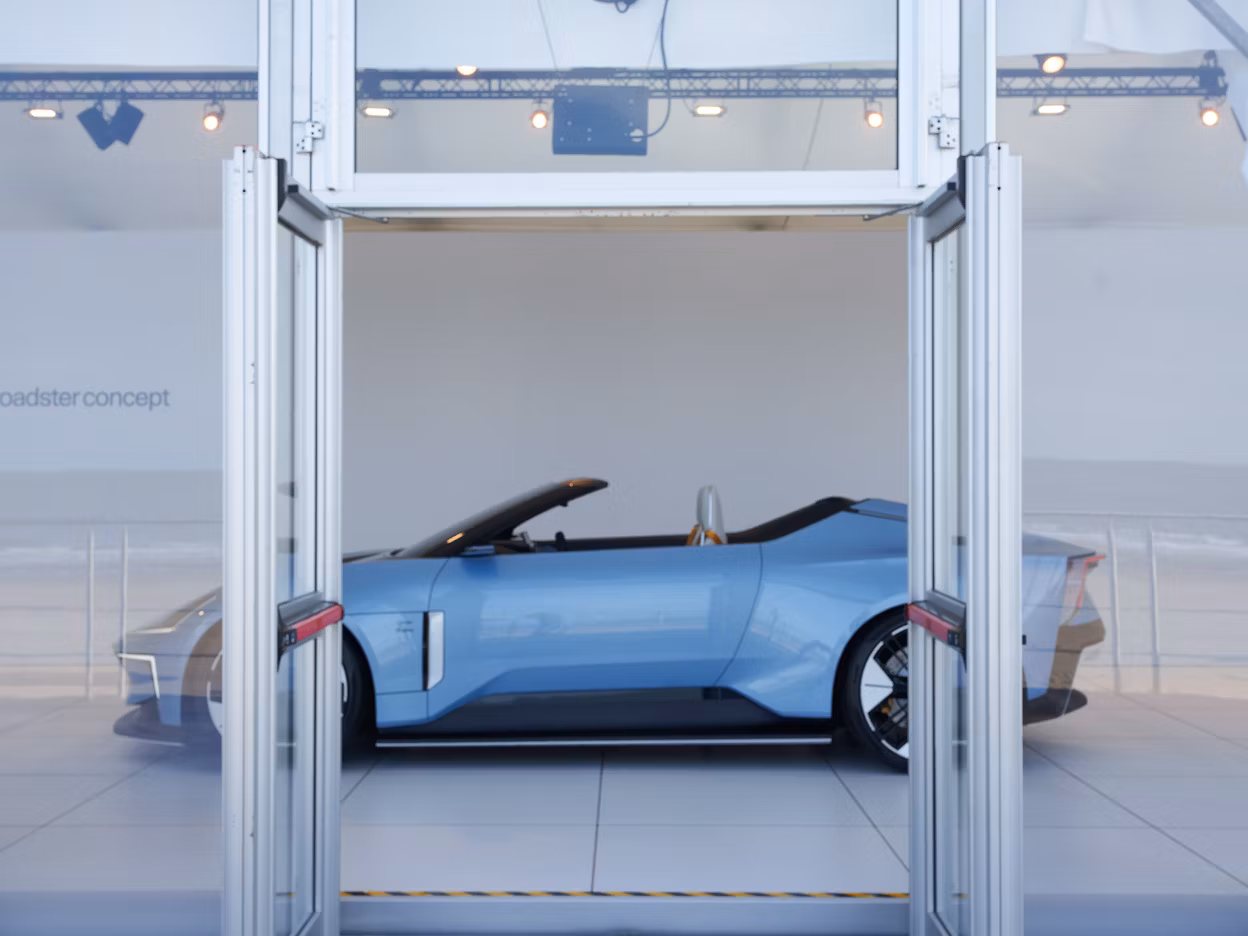 Polestar roadster concept car displayed indoors behind glass doors.
