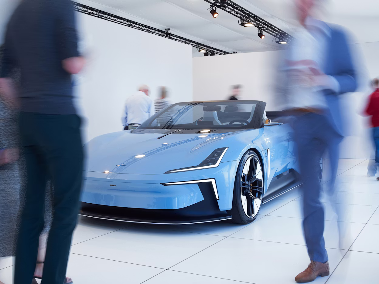 Polestar car displayed in a showroom with people walking around.