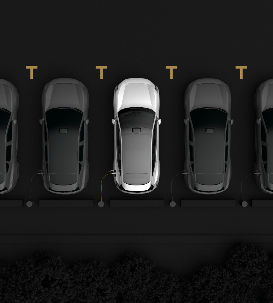 Cars parked in line seen from above.  One white car in the middle and black cars on both sides of it.