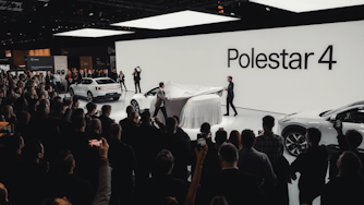 Two people unveiling a Polestar 4 car under a cover at the eCarExpo 2024