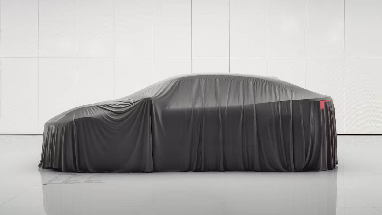 Polestar car covered with a black cloth in a white room.