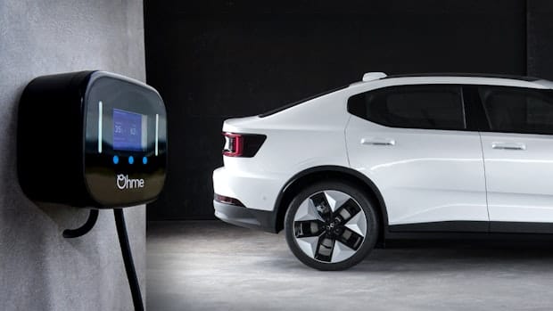A white Polestar 2 standing next to an Ohme home EV charger.