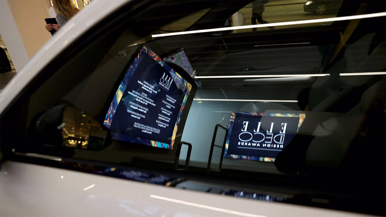 Looking through the window of a Polestar car, where you can see information displayed on a TV screen providing more details about the Elle Decoration Awards