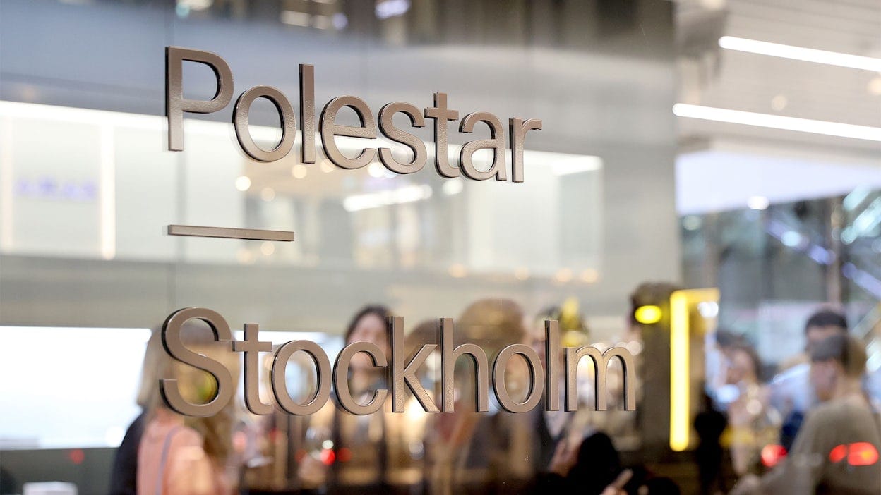 Front view zoomed in on a window featuring the Polestar logo alongside the words Stockholm. In the background, there is a group of participants of the Elle Decoration Awards 2024