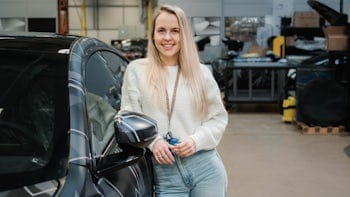 Bethany Martin standing next to a Polestar 5 prototype, smiling at the camera.