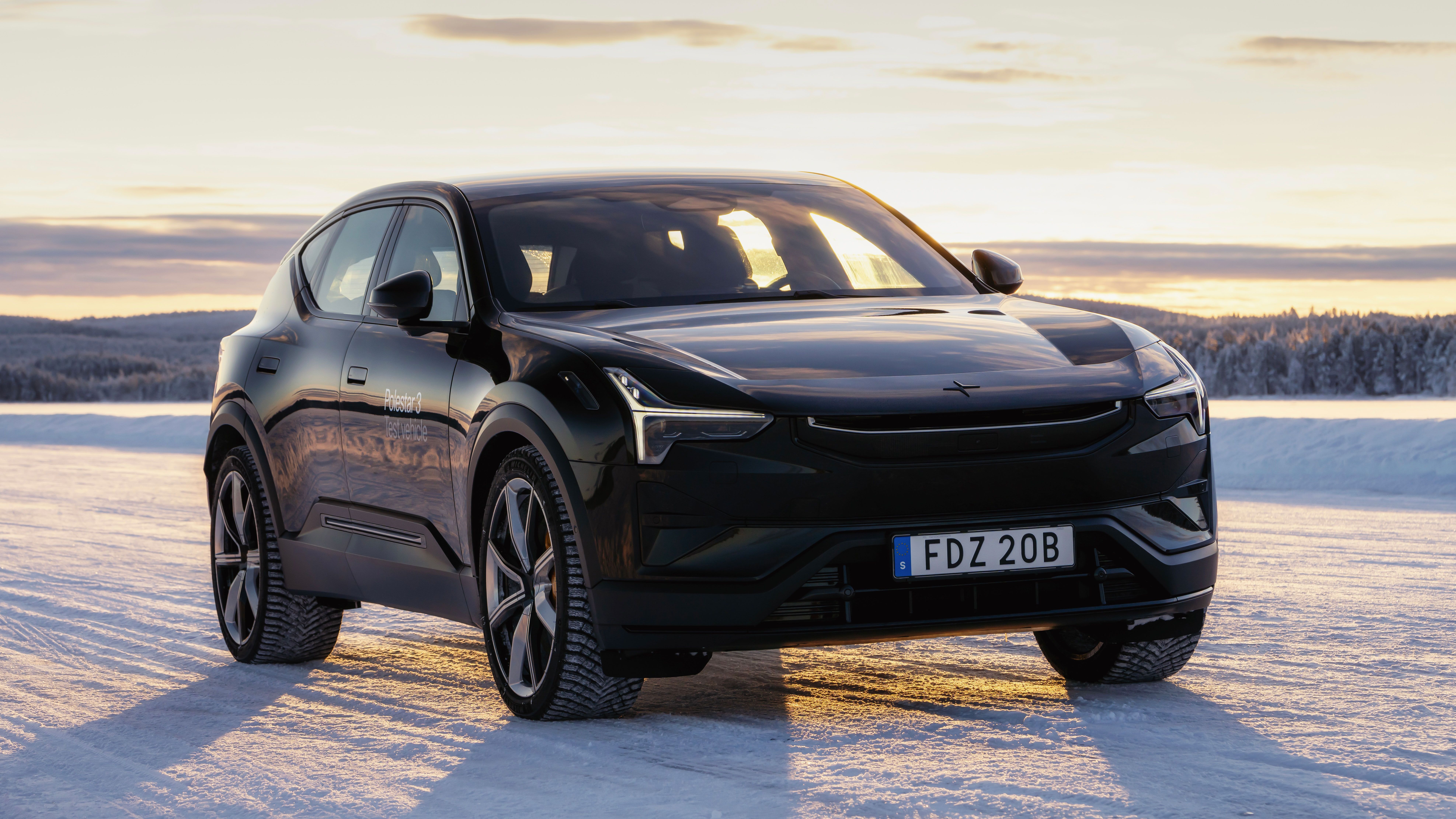 Polestar 3 in Space color stationary on a snowy road with sunrise behind the car
