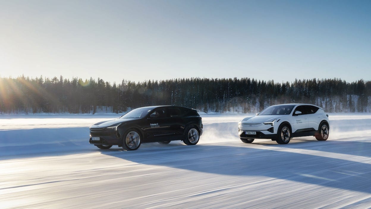 Two Polestar 3 vehicles, one in Snow color and the other in Space color, driving on a snowy road