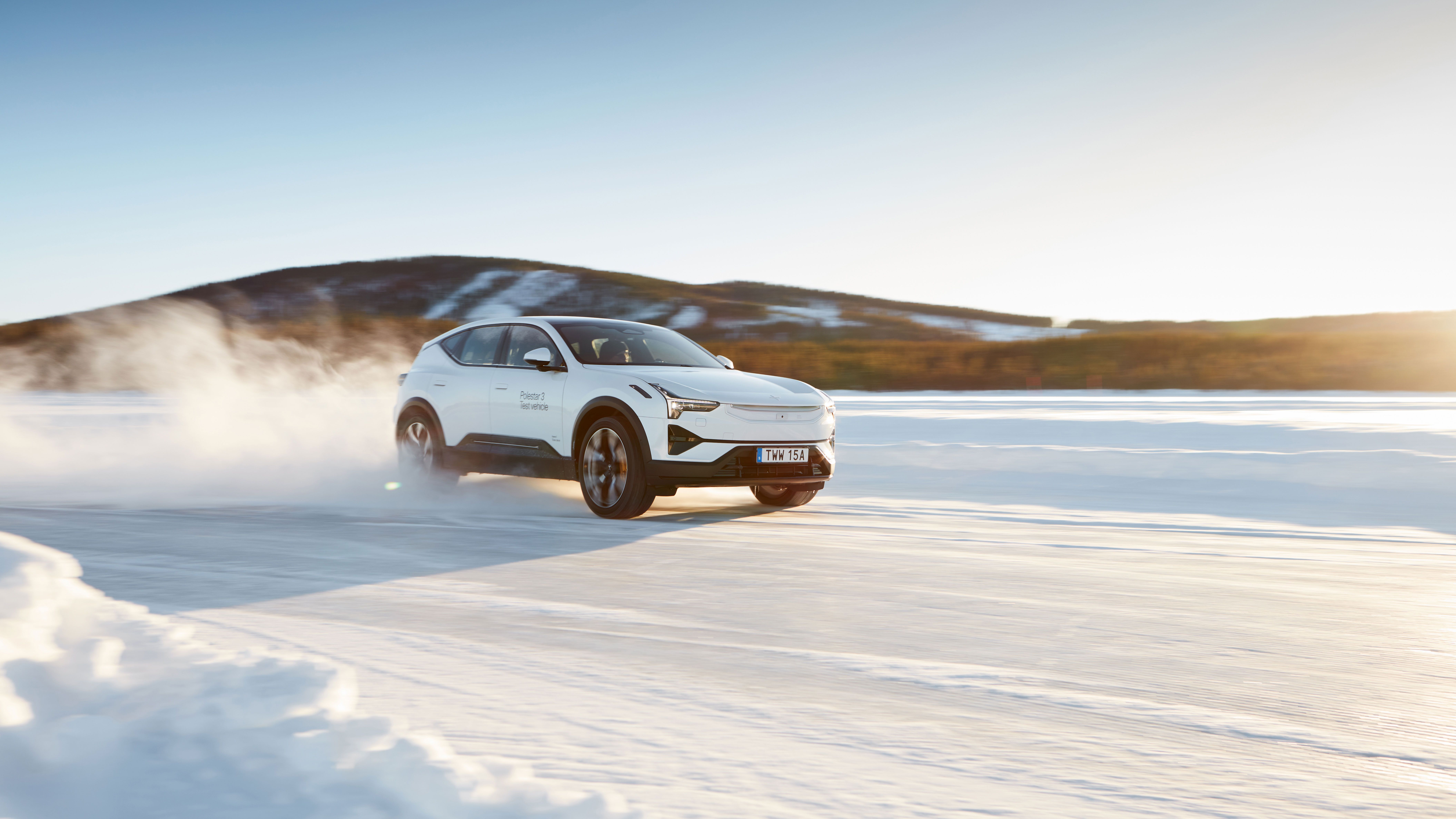 Polestar 3 in Snow color driving on a snowy road with the sun shining