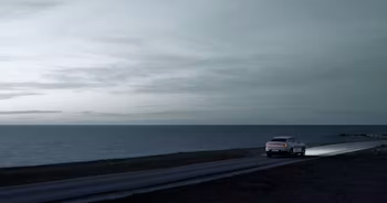 Polestar 2 rear view driving next to the sea
