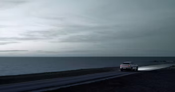 Polestar 2 rear view driving next to the sea