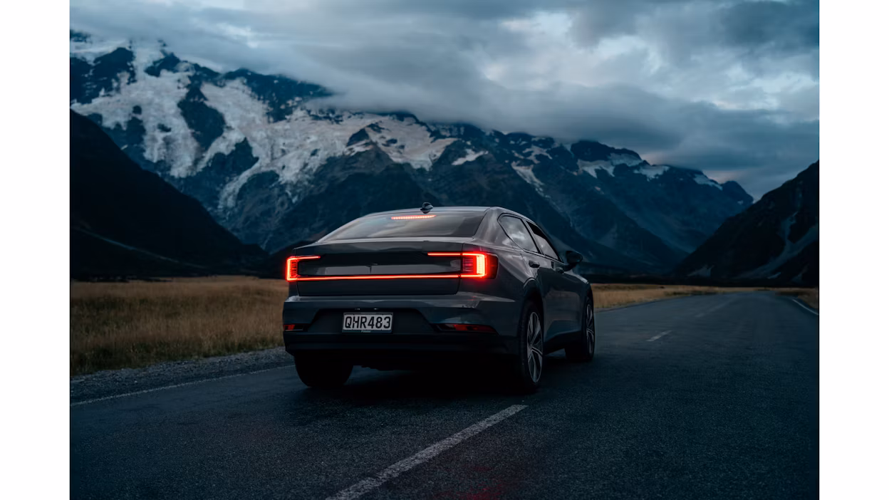 Rear view of Polestar 2 on a road overlooking the mountains of New Zealand