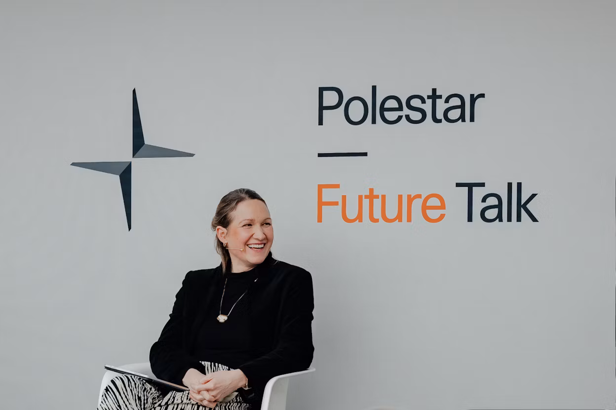 Polestar Future Talk text and logo on a wall, person seated in a chair holding a notebook.