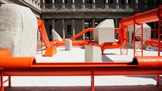 Large industrial orange pipes in old courtyard