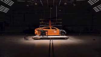Polestar 5 sits in the middle of crash test facility surrounded by lights