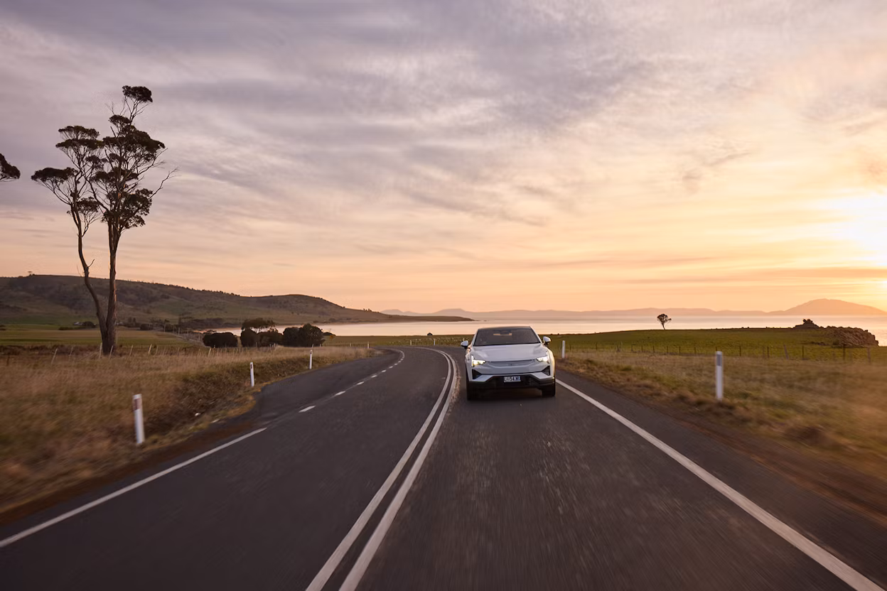 Polestar 3 driving down country road with sunset in background