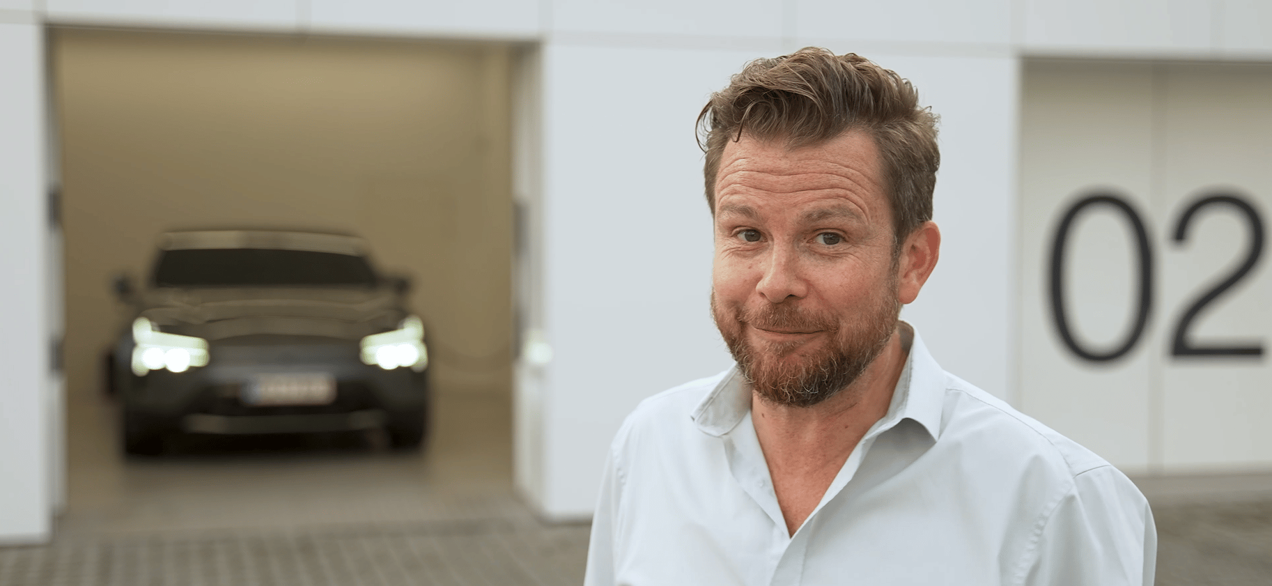 Polestar car parked in a garage with white walls and the number 02 displayed on the right side.