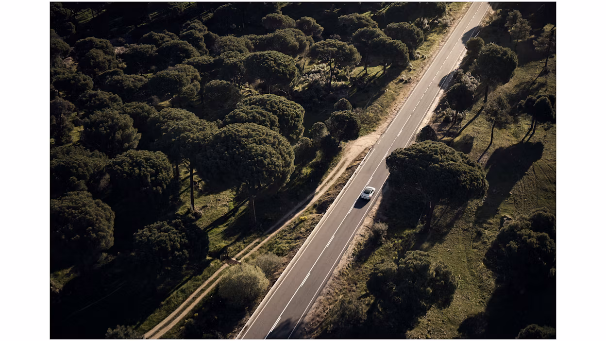 Polestar 4 rijdt op een lege weg vanuit de lucht gezien.