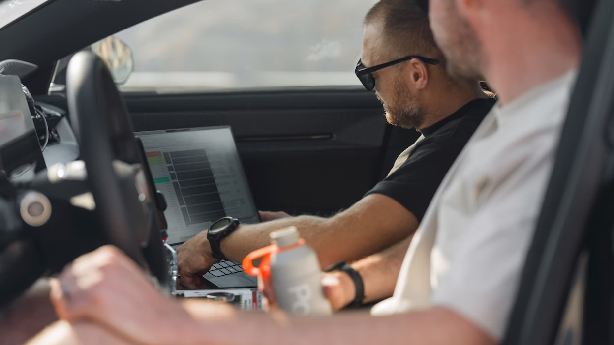 Engineers watching car data on laptop screen in Polestar 5