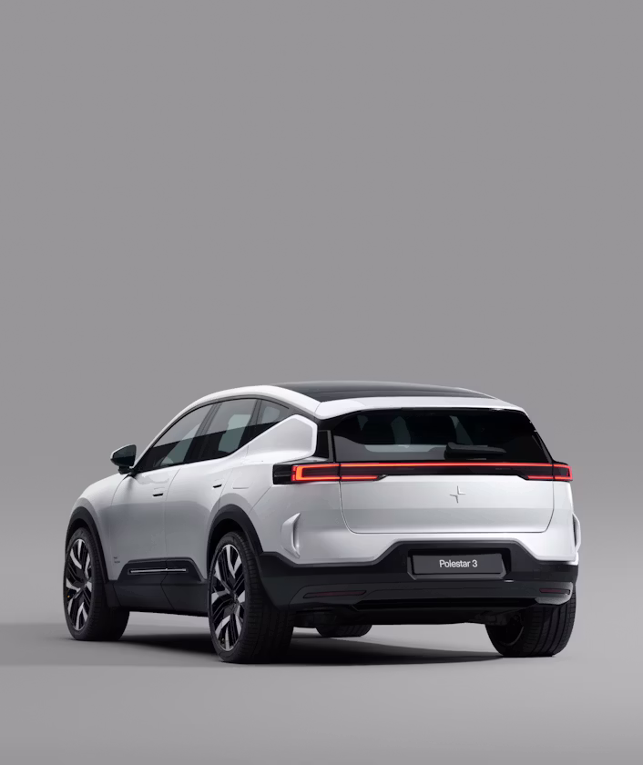 Rear side view of white Polestar 3 in studio setting with grey background